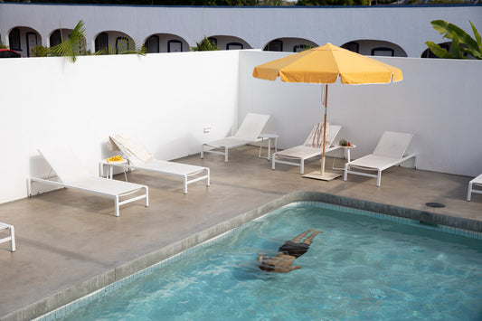 A market umbrella shading an outdoor table in a relaxed garden setting.