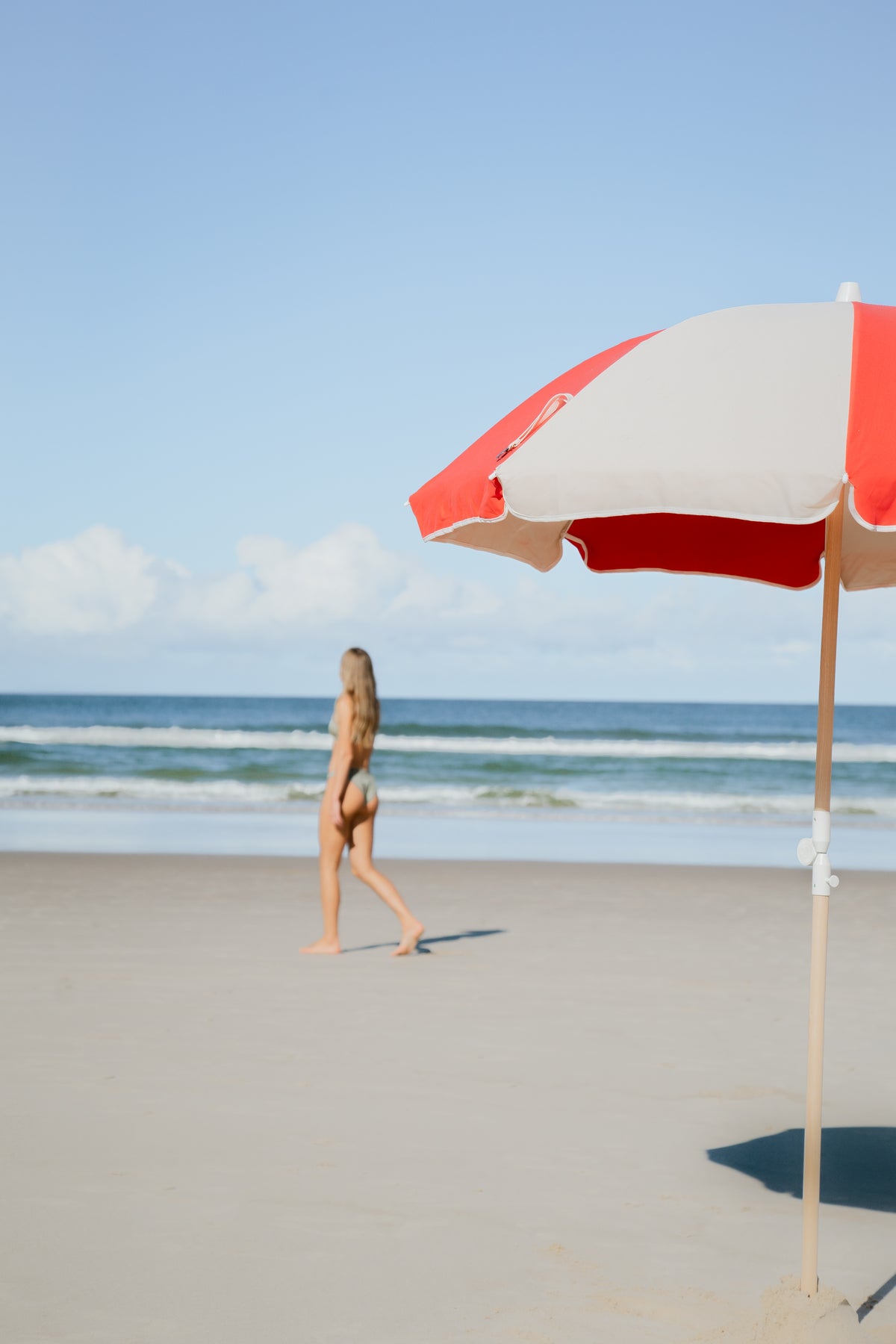 Rio Splice Beach Umbrella in the foreground of a beach walk