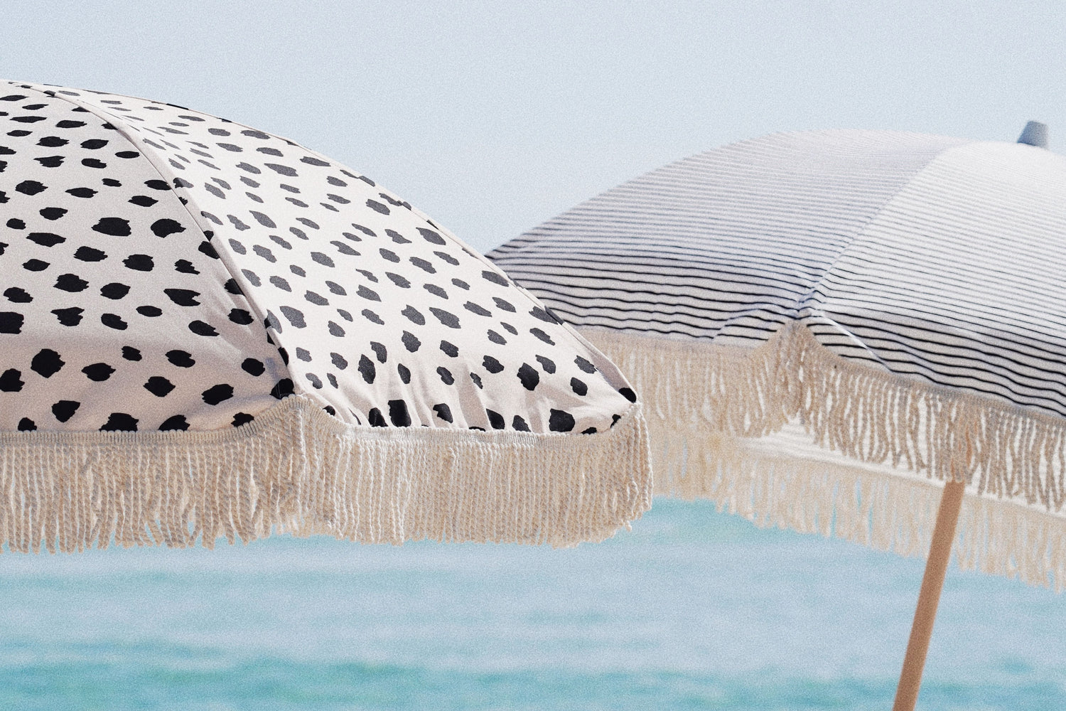 Spotted Beach Umbrella with tassels and Striped Beach Umbrella with Tassels by Sunday Supply Co. Australia